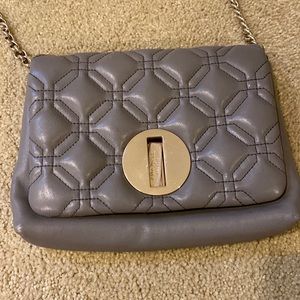 Grey Kate Spade crossbody bag with polka dot lining.